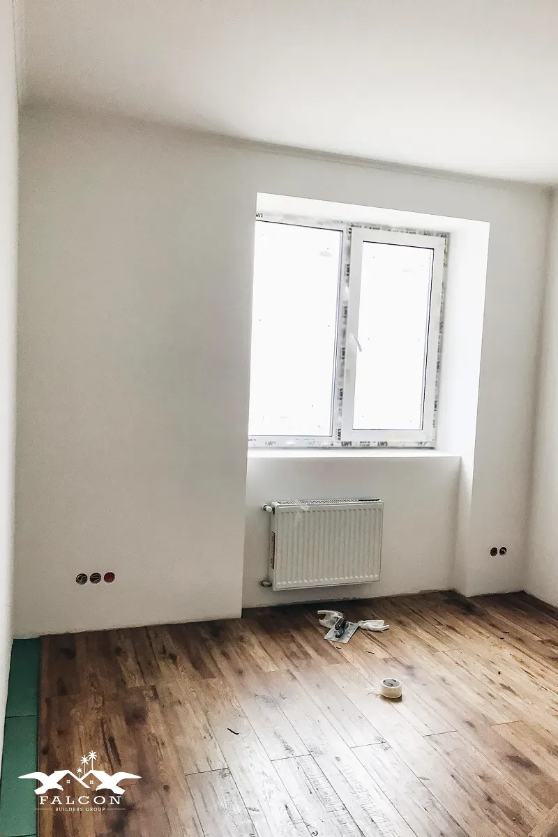 Interior painting in progress showing freshly painted walls, clean trim lines, and professional preparation in a residential room.