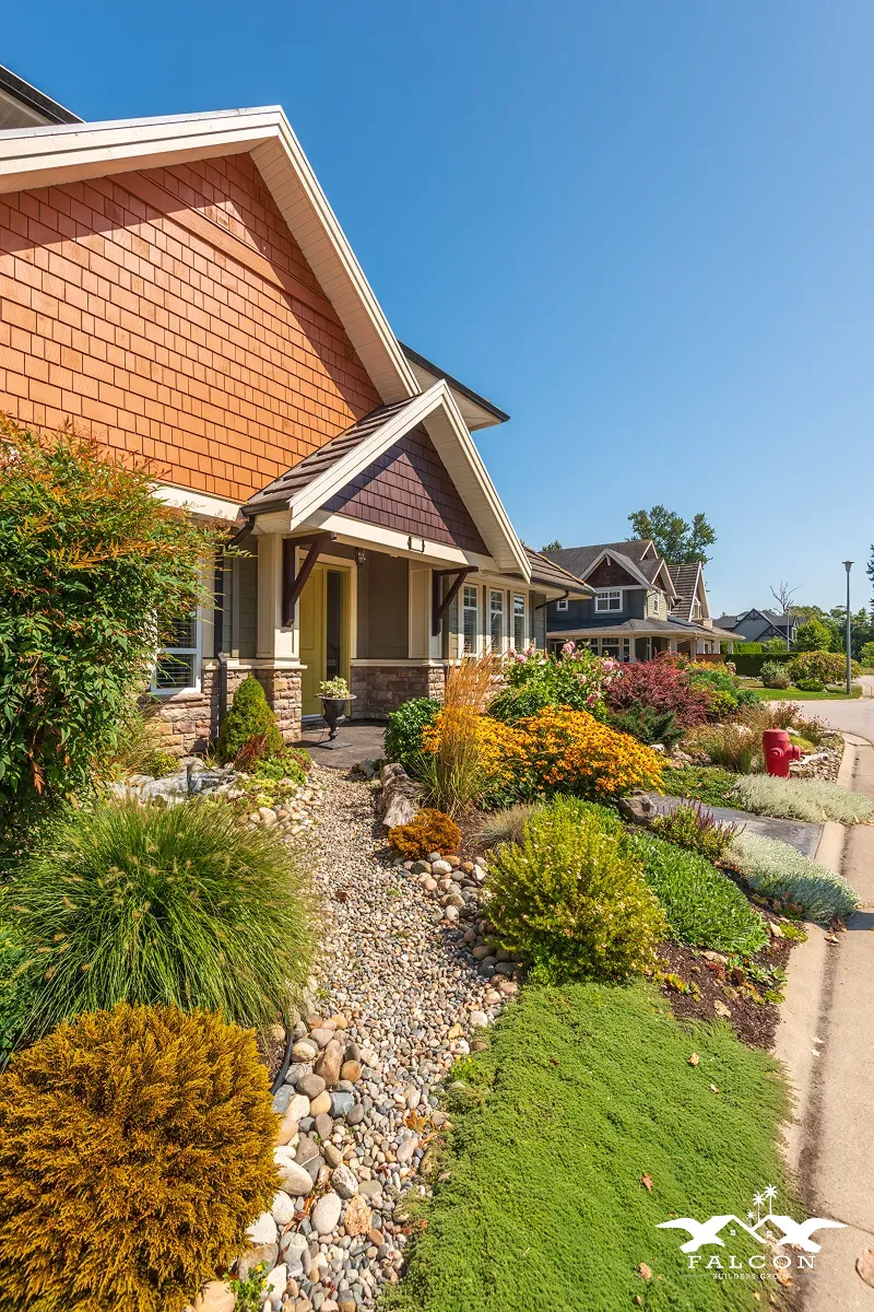 Residential landscape design featuring drought-tolerant plants, decorative stone pathways, layered shrubs, and professionally installed front yard landscaping.