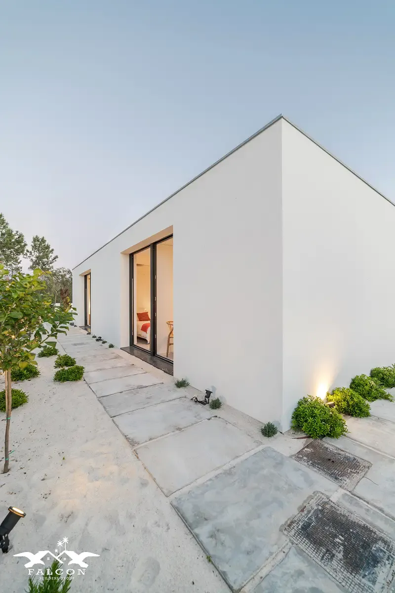 ADU construction in San Diego featuring a modern detached accessory dwelling unit with smooth exterior walls, large sliding doors, clean concrete pavers, and minimalist landscaping designed for functional and stylish backyard living.