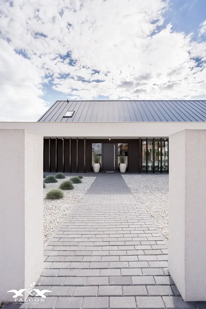 Concrete services in San Diego featuring a modern paver walkway leading to a contemporary home entrance, showcasing clean hardscape design, durable concrete installation, and low-maintenance landscaping.