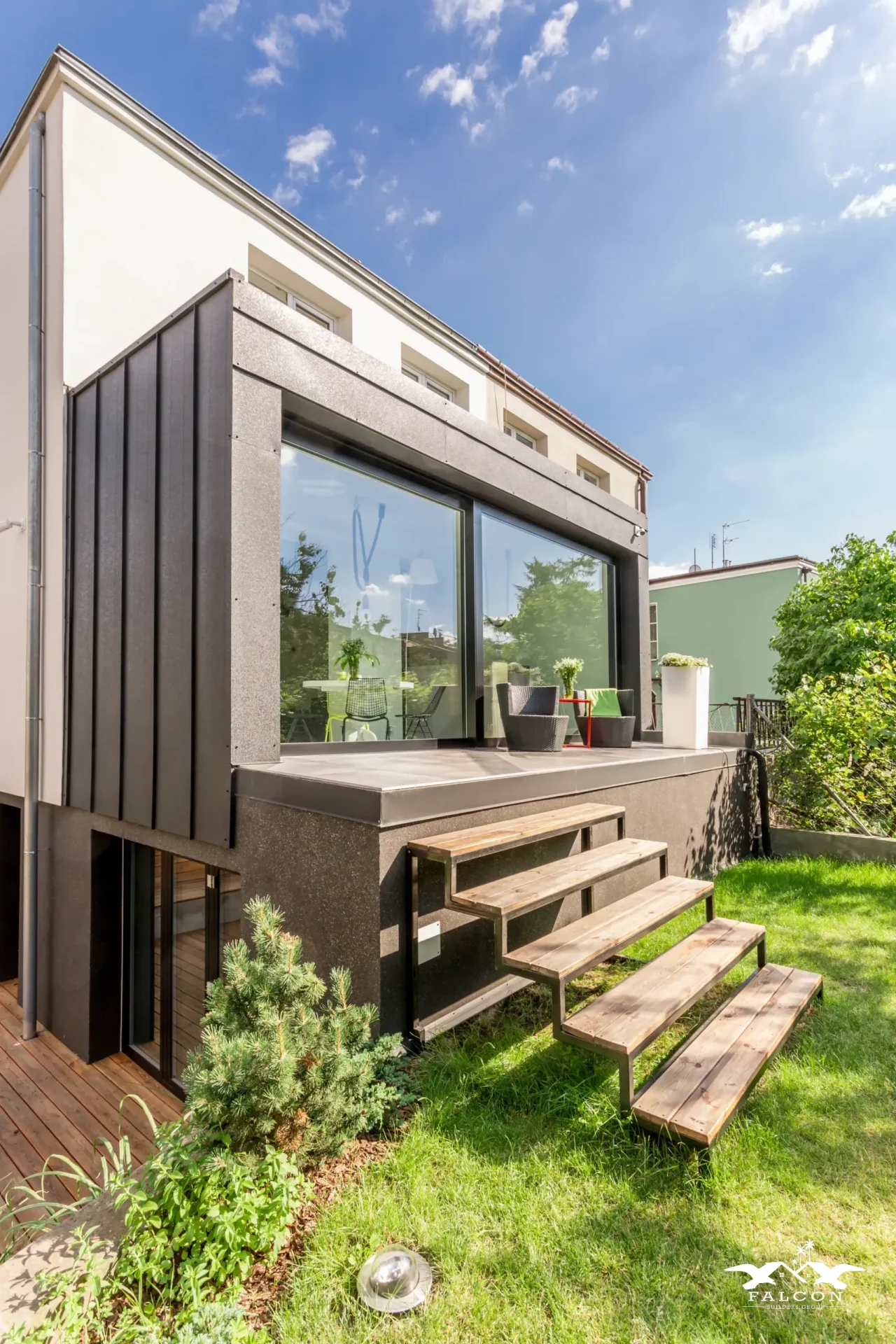An ADU construction project featuring modern backyard accessory dwelling unit with large sliding glass doors, elevated patio, and custom exterior steps.