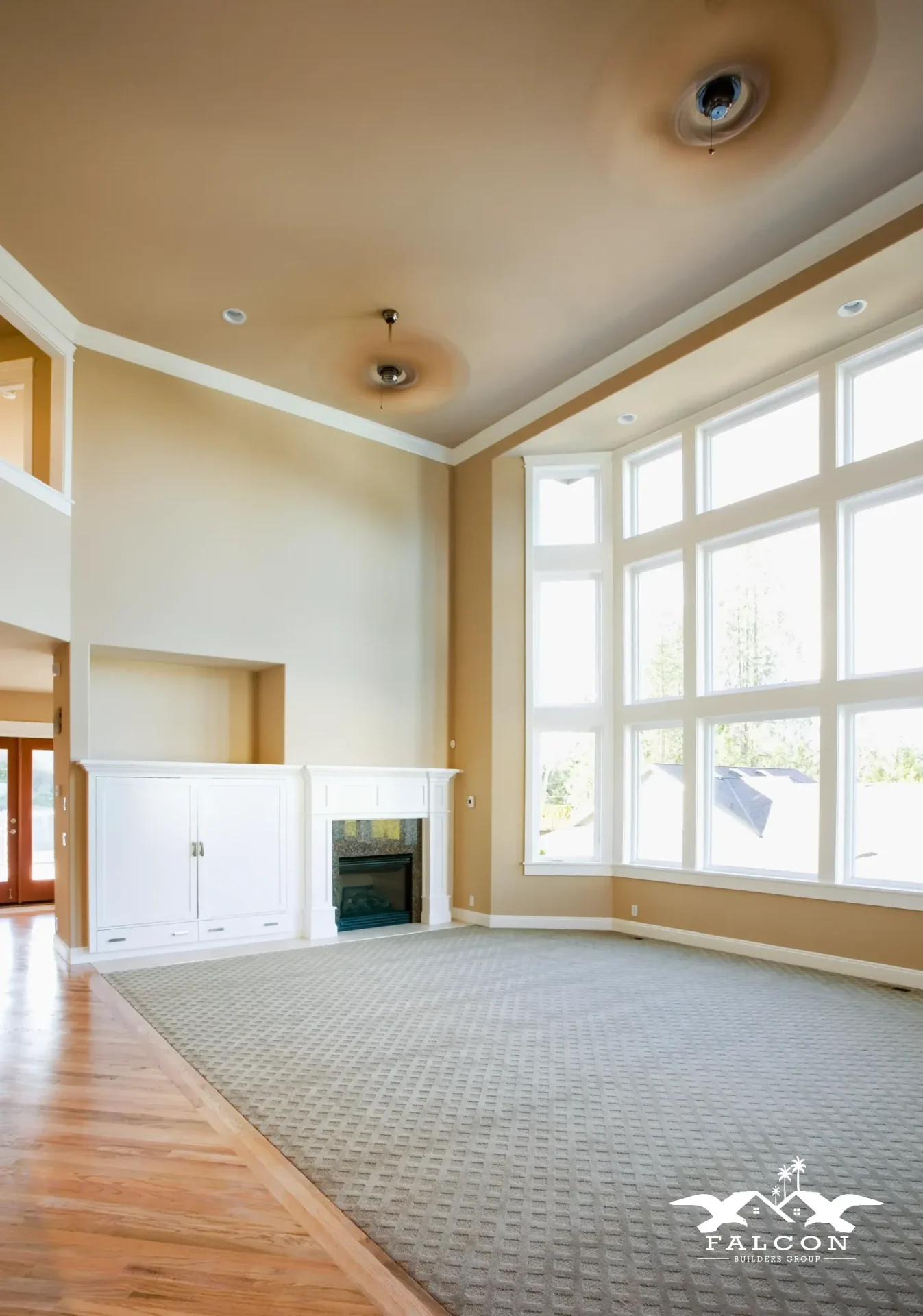 Interior painting service featuring freshly painted warm neutral walls and crisp white trim in spacious living room with high ceilings and large windows.