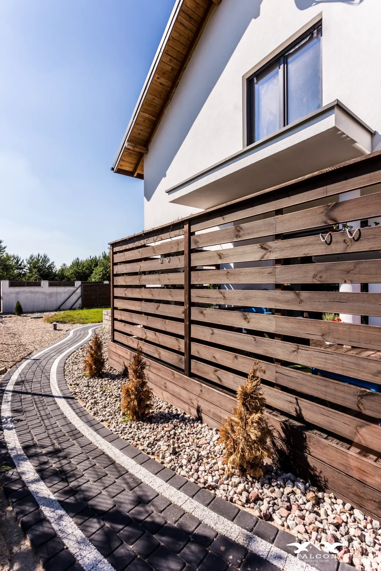 Professional fence installation featuring modern horizontal wood privacy fence with landscaped pathway along residential property.