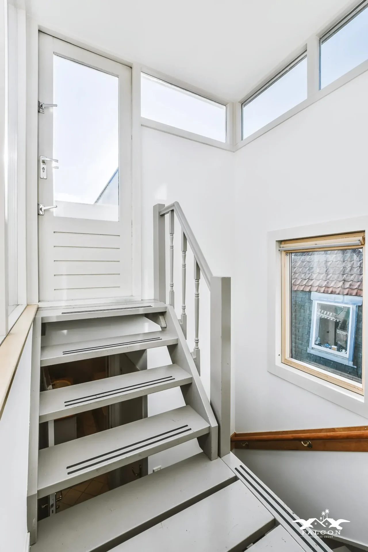 ADU construction interior featuring compact staircase, loft access, and bright natural lighting for efficient small-space design.