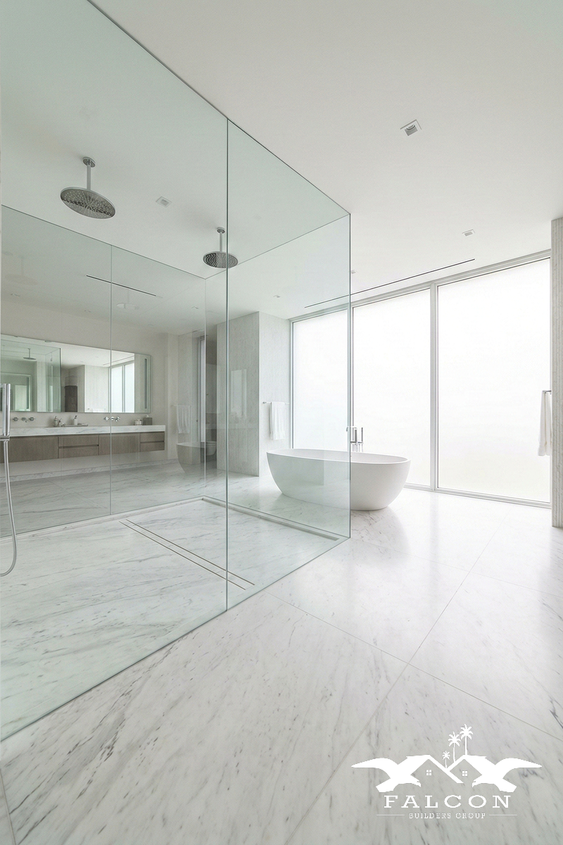 Modern bathroom remodel featuring frameless glass walk-in shower, freestanding soaking tub, marble flooring, and sleek double vanity design.