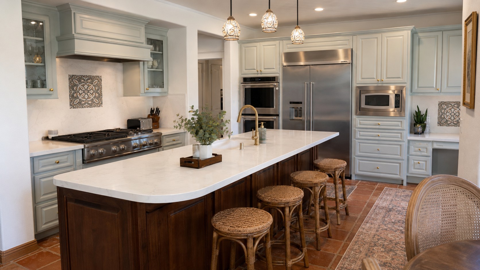 A newly remodeled kitchen on McCall St, San Diego, featuring a long island with white countertop, wooden base, four wicker stools, light gray cabinets, stainless steel oven, microwave, and fridge, pendant lights above, and decorative tile backsplash.